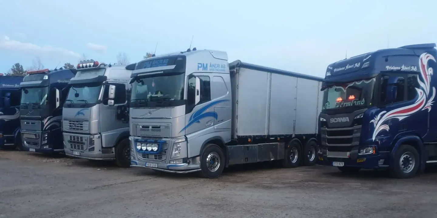 Maskintrailer med en stor maskin på väg längs vägen